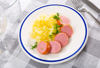 Boiled sausages frankfurter with mashed potato slices are served on plate. Traditional European breakfast