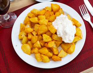 Patatas Bravas, classic Spanish tapas dish, are crispy fried potatoes served with spicy sauce
