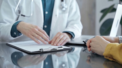 Fototapeta premium Doctor and patient consultation in clinic. Patient listens attentively as a doctor explains a diagnosis in a modern medical office. Medicine and health care