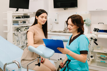 Gynecologist Exam with Colposcopy Equipment. Gynecologist prepares for a pelvic examination with...