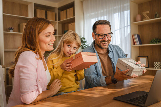 Family celebrating birthday with gifts during video call