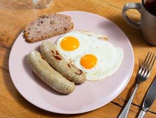 Delicious fried eggs with sausage served on platter for breakfast