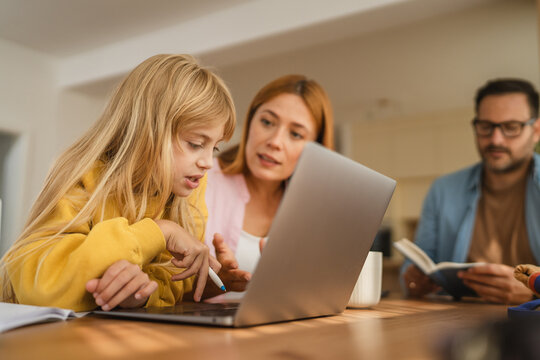 Mother and daughter learning online with father working remotely - Powered by Adobe