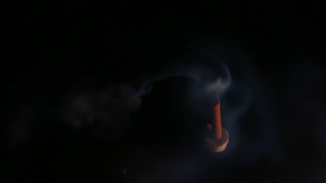 Smoldering aroma incense on dark background with natural atmosphere concept smoke. Magic calm waves from herb incense. Therapy and spa fumigation concept