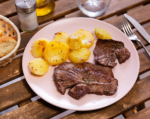 Appetizing grilled beef steak served on platter with potatoes