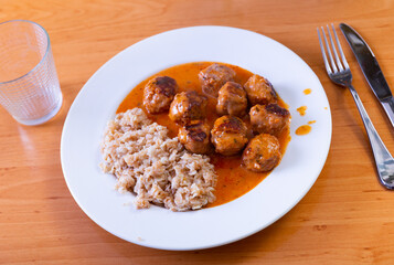 Delicious oatmeal porridge served with meatballs on platter