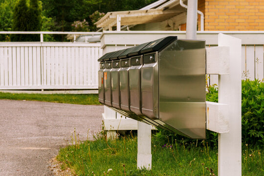 Row of mailboxes with residential houses in Finnish town