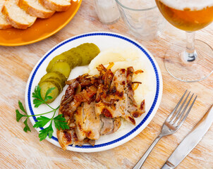 Delicious pork steak served with potatoes and pickles. Festive dinner