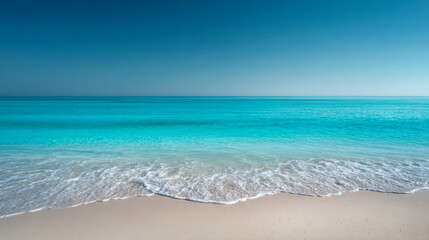 Serene view of gentle waves washing onto pristine sandy beach under clear blue sky on a calm tropical coastline
