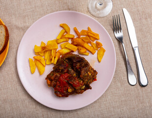Delicious baked pork cheek served on platter with vegetables and potatoes