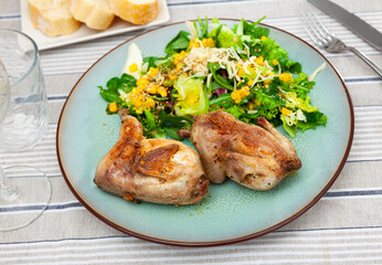 Delicious fried quail served on plate with fresh vegetable salad