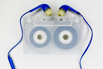 close up of dirty transparent cassette tape with earphone isolated on white background