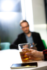 Businesspeople engaged in discussion over drinks in a modern office setting during evening hours