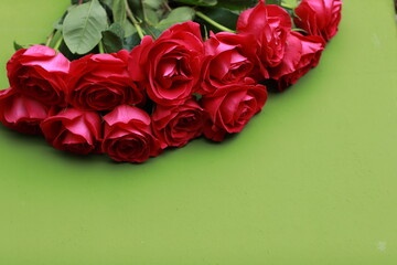 Red roses on a green background, bouquet of flowers, top view, free space, place for text, background