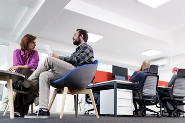 Business discussion takes place in modern office setting during work hours between two professionals