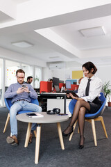 Obraz premium Business meeting in modern office with professionals working on their devices during a relaxed moment