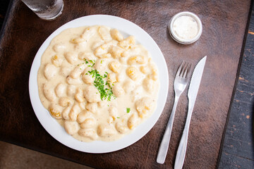 vegan gnocchi dish with four cheese sauce in top view restaurant with cheese