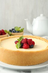 Delicious cheesecake with fresh berries served on white marble table, closeup