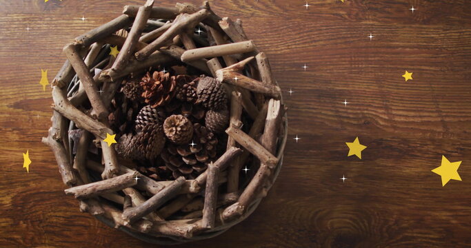 Naklejki Image of stars over wreath with branches and cones on wooden background