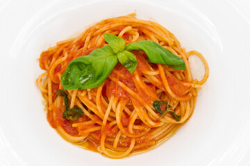 Classic Italian pasta, Spaghetti with tomato sauce and basil on a white plate