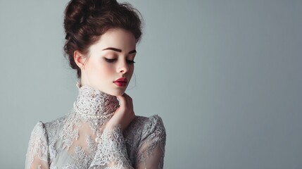 A woman with dark hair, soft makeup, and a lace dress adorned with a pearl necklace, gazing down