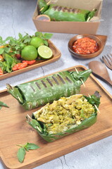 Grilled rice with shredded chicken and green chilies, wrapped in banana leaves, traditional Indonesian food