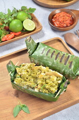 Grilled rice with shredded chicken and green chilies, wrapped in banana leaves, traditional Indonesian food