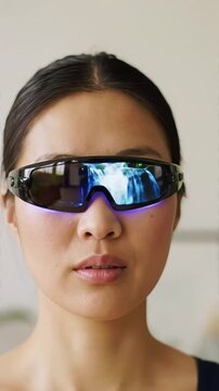 Young Asian Woman Wearing Futuristic Smart Glasses with an Immersive Digital Waterfall Display Showcasing Augmented Reality and Innovative Tech Vision