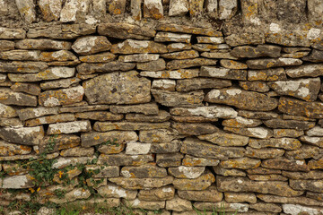 Old dry stone wall texture with natural rocks, lichen, and ancient pattern, creating a rustic background