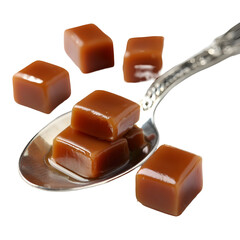 Caramel candy cubes arranged on decorative silver spoon against transparent background