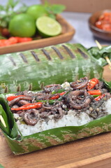 Grilled rice with stir-fried squid, wrapped in banana leaves, a traditional Indonesian dish
