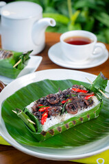 Grilled rice with stir-fried squid, wrapped in banana leaves, a traditional Indonesian dish