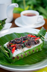 Grilled rice with stir-fried squid, wrapped in banana leaves, a traditional Indonesian dish