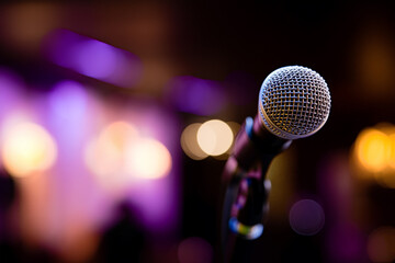 Microphone on stand with colorful stage lights and bokeh in a concert venue. Generative AI