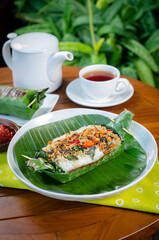 Grilled rice with anchovies and tempeh, wrapped in banana leaves, a traditional Indonesian dish