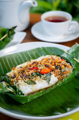 Grilled rice with anchovies and tempeh, wrapped in banana leaves, a traditional Indonesian dish