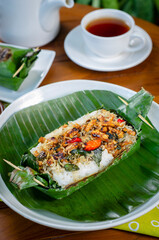 Grilled rice with anchovies and tempeh, wrapped in banana leaves, a traditional Indonesian dish