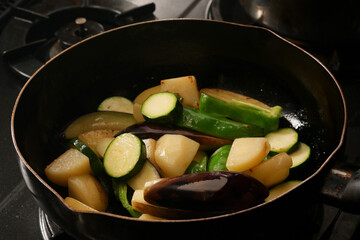 フライパンで野菜を炒めている　