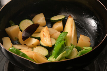 フライパンで野菜を炒めている　