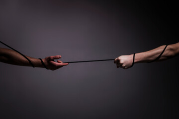 Rescue, help, helping gesture or hands. Conflict tug of war. Rope, cord. Hand holding a rope,...