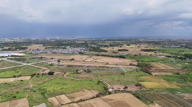 Aerial Drone Shot of Rural Village and Farmland in Malolos, Bulacan, Philippines with Trees and Overcast Rainy Sky