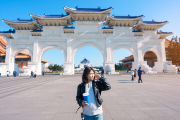 Fototapeta premium woman hand holding Pearl bubble milk tea glasses. traveler at National Chiang Kai shek Memorial, a famous beverages in Taipei, Taiwan