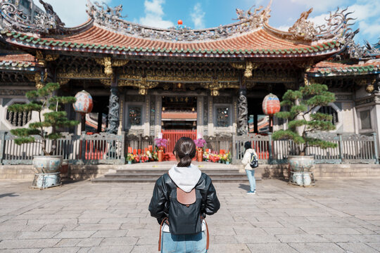 woman traveler visiting in Taiwan, female Tourist sightseeing at Longshan Temple, Chinese folk religious temple in Wanhua District, Taipei City. landmark and popular. Travel and Vacation concept