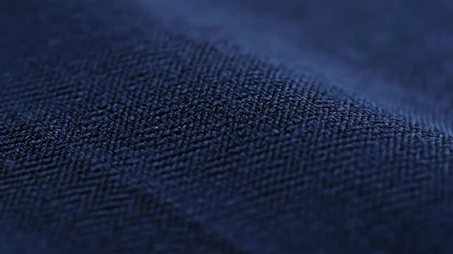Detailed Texture of Dark Blue Herringbone Fabric Swaying Gently Under Soft Lighting Showing Intricate Weave Pattern and Subtle Movements Ideal for Fashion Design and Textile Industry Applications