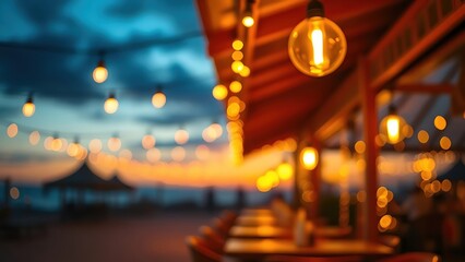 Golden sunset glow illuminating a beach restaurant with soft reflections of string lights.