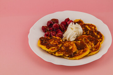 Delicious pancakes topped with caramel and fresh raspberries for breakfast