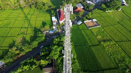 Rare Stunning Drone Aerial Telecommunication Tower Wireless Internet WiFi 5G Above Countryside Landscape in Green Rice Fields during day in 4K - Powered by Adobe
