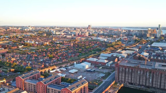 Cinematic Drone Footage of Liverpool Centre Outskirts Showing a train going past. Liverpool housing and the key areas in the distance are present.