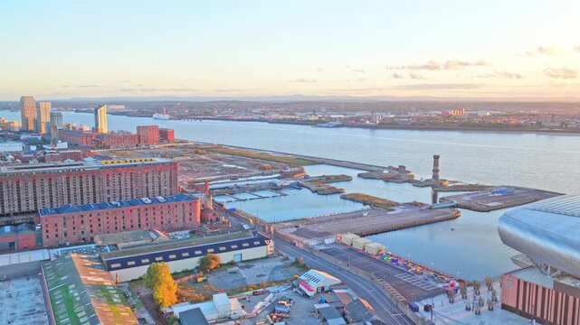 Aerial drone footage of the area surrounding Bramley-Moore Dock in Liverpool, UK, filmed at sunset. This golden-hour footage captures residential streets, local housing, docklands, the River Mersey.