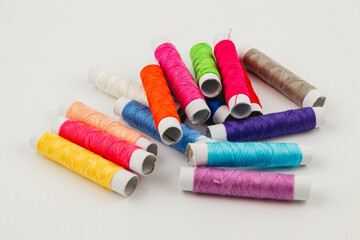 Colorful sewing threads arranged on a white surface for craft projects